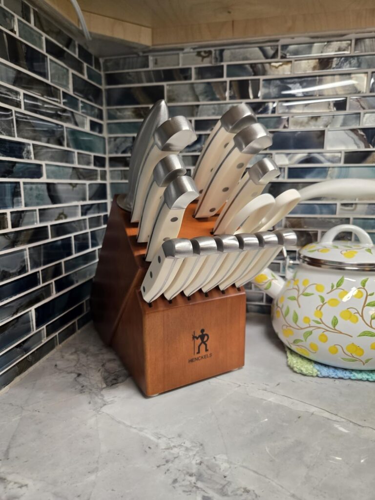 Authentic home kitchen view of the HENCKELS Statement 15-Piece Knife Set block on a granite countertop, showing practical size."