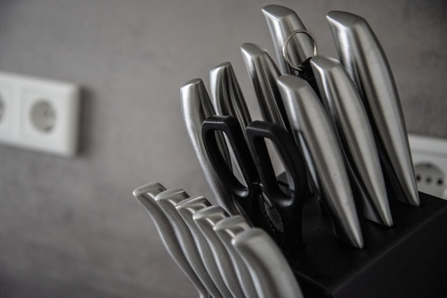 "Modern professional kitchen knife set with metal handles on a modern kitchen counter"